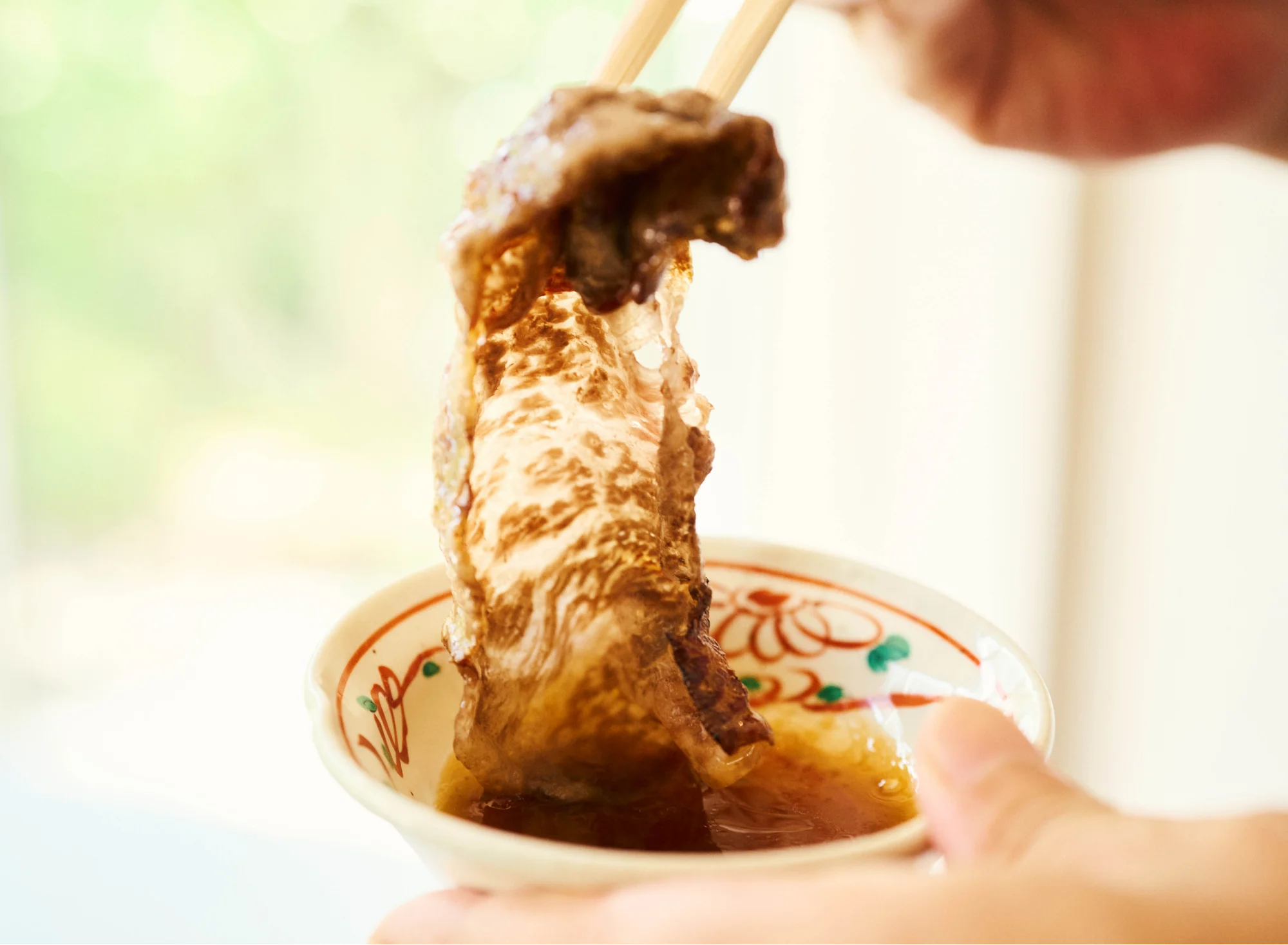 浅虫温泉 椿館の夕食。陶板で焼き上げた青森のブランド牛「NAMIKI牛」をタレにくぐらせる、とろけるような食感を楽しむ贅沢なひととき