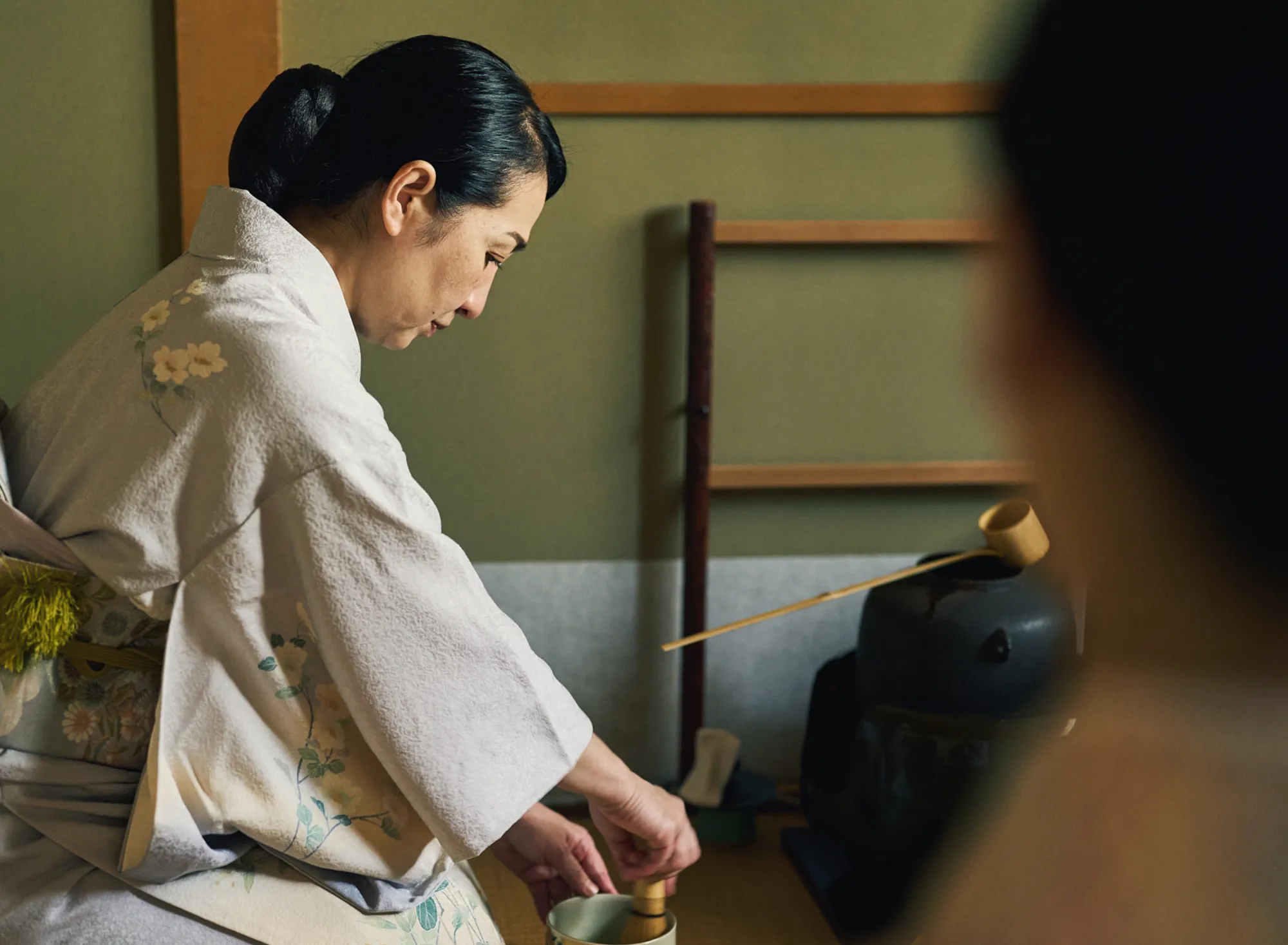 浅虫温泉 椿館の茶道体験。本格的な茶室にて、茶筅でお抹茶を丁寧に点てる亭主の美しい所作。静寂の中に響く音とともに、心を落ち着かせ和の心に触れる体験のワンシーン