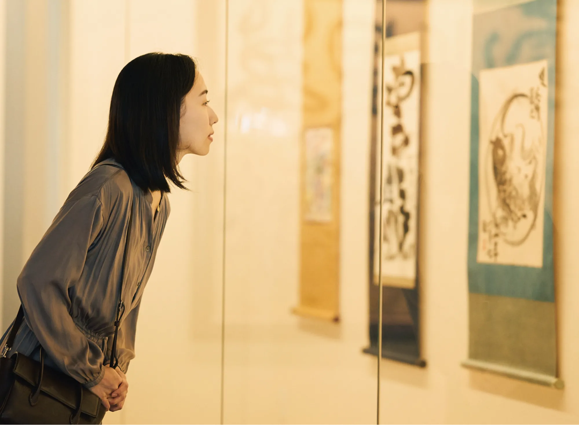 浅虫温泉 椿館の棟方志功ギャラリーで、展示された貴重な倭画や掛け軸を間近で熱心に鑑賞する様子