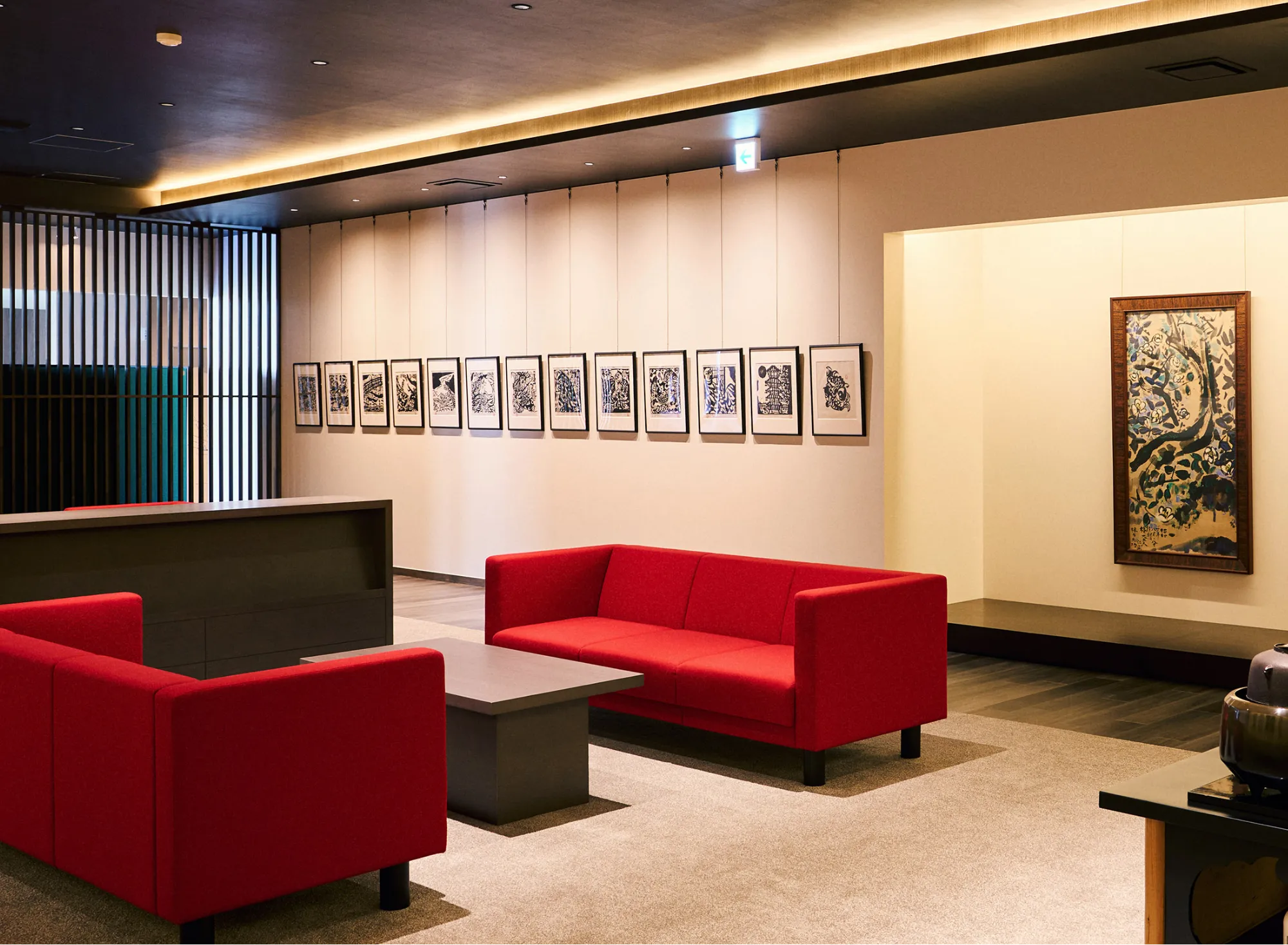 浅虫温泉 椿館の棟方志功ギャラリー。壁一面に並ぶモノクロの板画（版画）と、右側の展示スペースに飾られた色鮮やかな倭画の大作