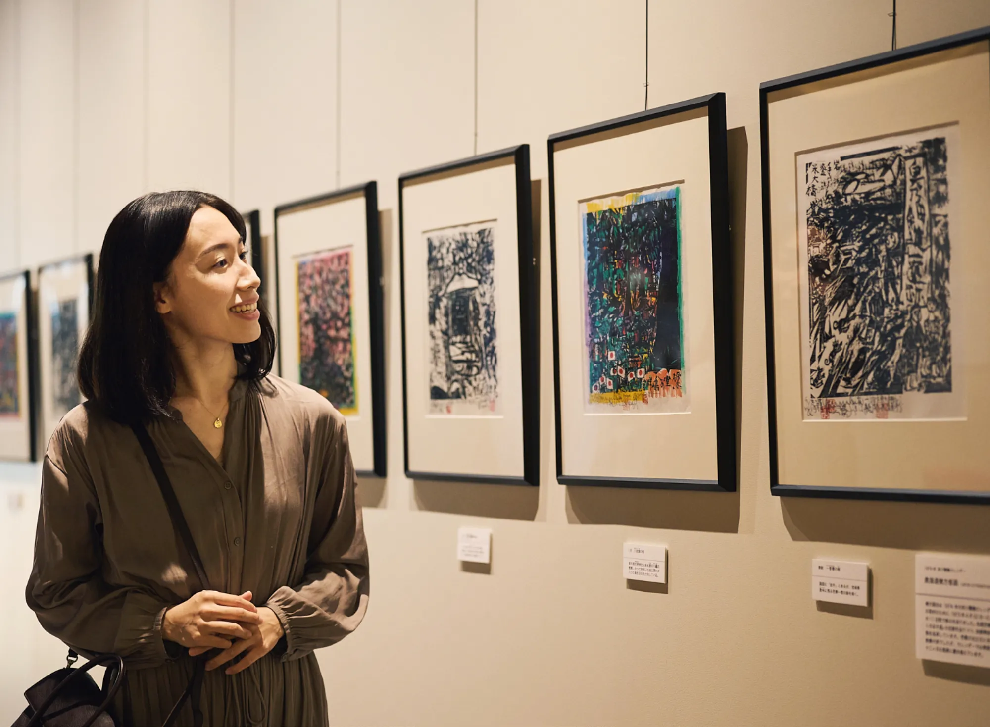 浅虫温泉 椿館の棟方志功ギャラリーにて、鮮やかな色彩が美しい棟方志功の彩色板画（版画）を笑顔で鑑賞する様子