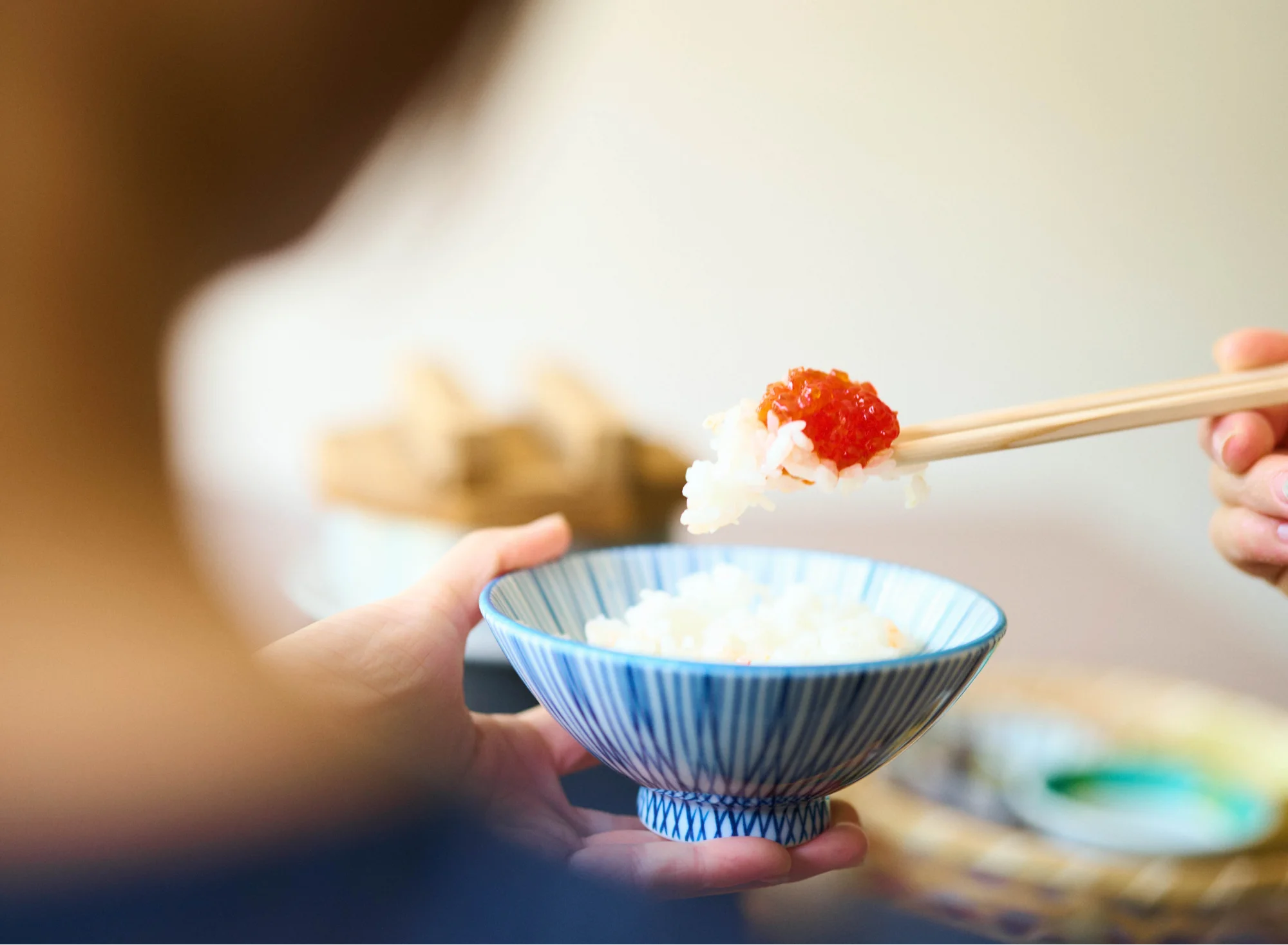 浅虫温泉 椿館の朝食。釜炊きのご飯に「すじこ」をのせて頬張る、青森ならではの贅沢な朝のひとときを堪能する様子