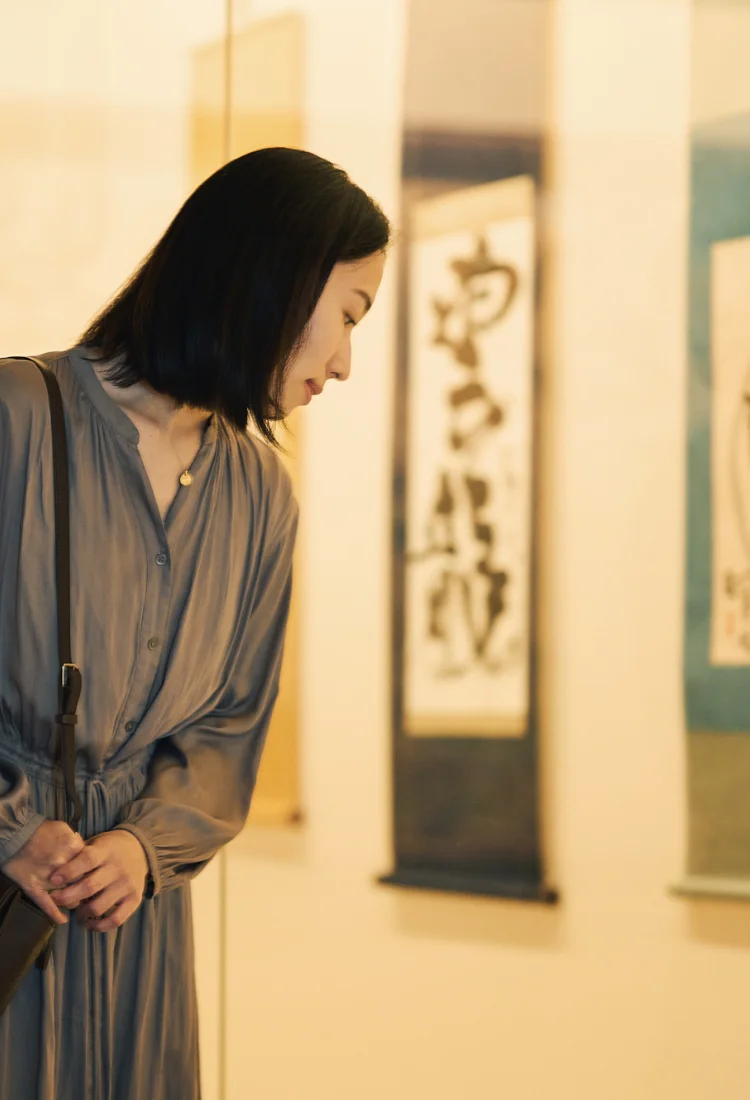 棟方志功ゆかりの宿、椿館のギャラリーで巨匠の作品に見入るひととき。館内に息づく数々のアートに触れ、歴史と文化の香りに包まれる穏やかな滞在のワンシーンを映し出した情緒的なビジュアル