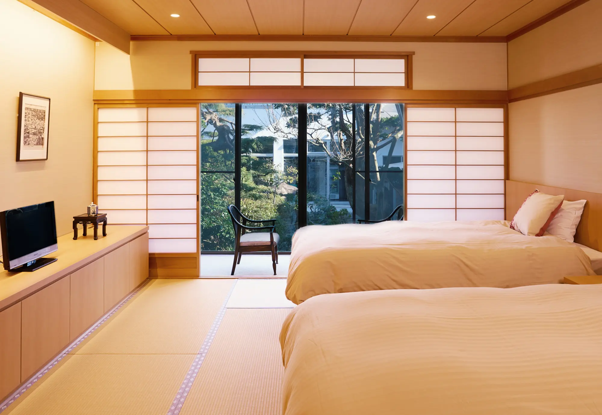 浅虫温泉 椿館。日本庭園の緑に癒される和洋室。畳の心地よさとベッドの快適さを兼ね備えた、上質なプライベート空間